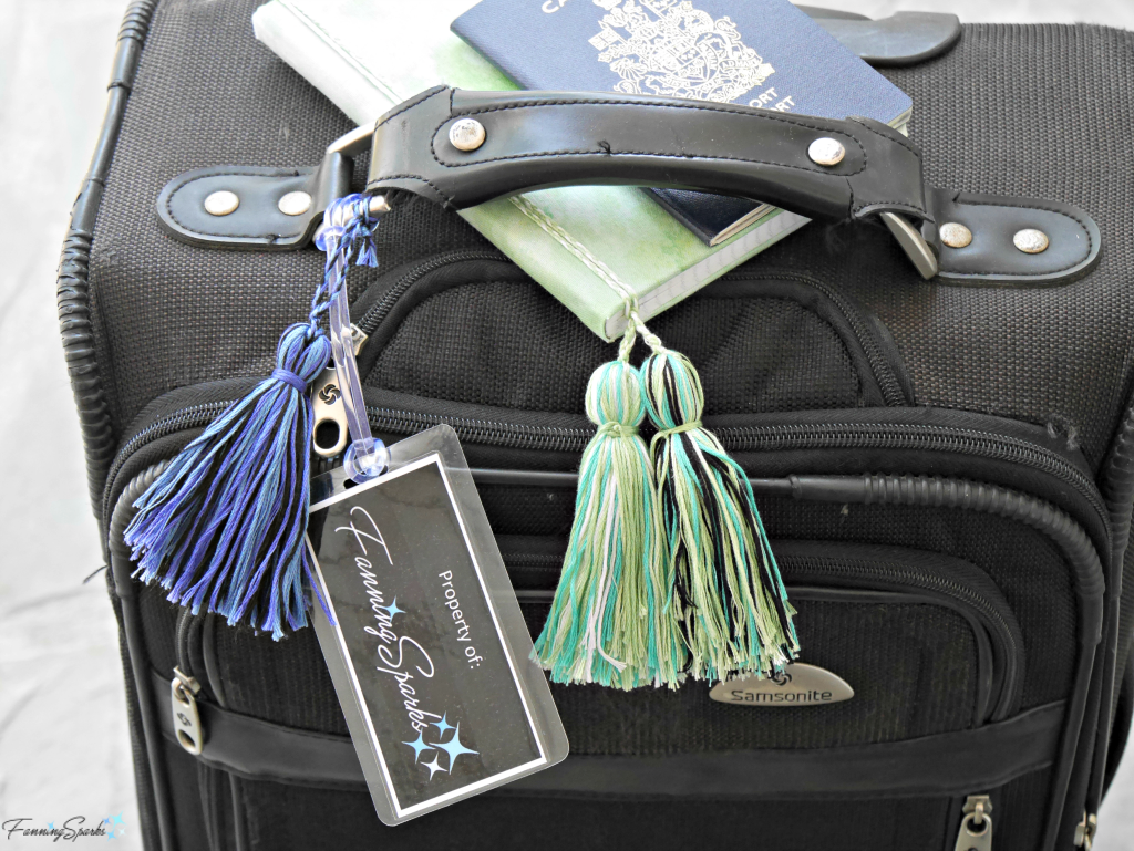 Suitcase shown FanningSparks tag, passport and tasseled notebook @FanningSparks