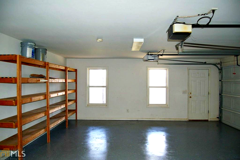 Garage showing 2 bays, built in shelving and window wall. @FanningSparks