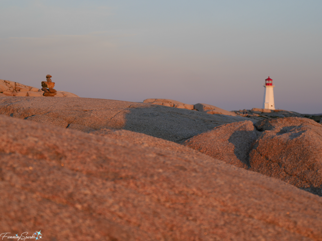 Peggy's Point Lighthouse and an inukshuk during golden hour. @FanningSparks