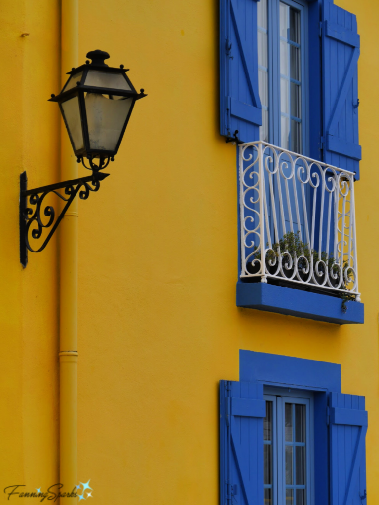 Vibrant Yellow Wall Showcases Wrought Iron Light Fixture in Aveiro Portugal.  @FanningSparks